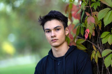 Sonbahar doğal ortamında sonbahar kıyafetleri içinde genç ve yakışıklı bir adam.