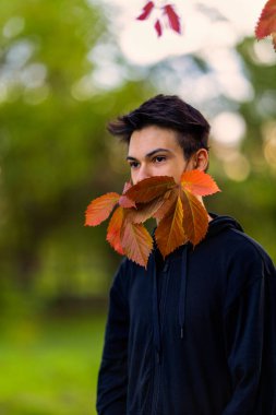 Yaprak maskeli genç bir adamın sonbahar portresi