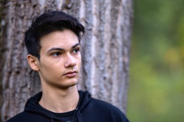 Sonbahar doğal ortamında sonbahar kıyafetleri içinde genç ve yakışıklı bir adam.