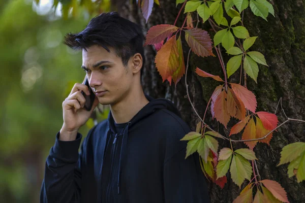 Ung Man Med Mobiltelefon Höstparken — Stockfoto