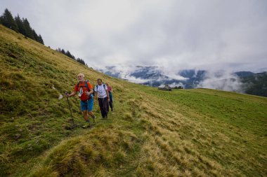 Bulutlu ve sisli bir günde büyükbabalarıyla dağlarda yürüyen bir çift..