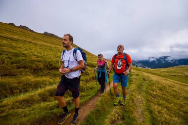 Bulutlu ve sisli bir günde büyükbabalarıyla dağlarda yürüyen bir çift..