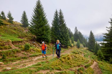 Turistler bulutlu bir sonbahar gününde dağ yolunda