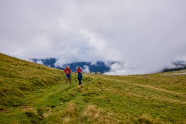 Turistler bulutlu bir sonbahar gününde dağ yolunda