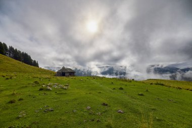 Romanya 'nın Bucegi Dağları' nda terk edilmiş ahşap ağılı dağ manzarası bulutlu bir Eylül gününde