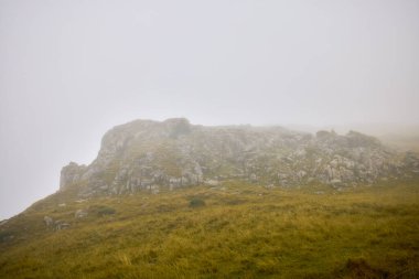 Yağmurda sisli kayalık bir dağ sırtı