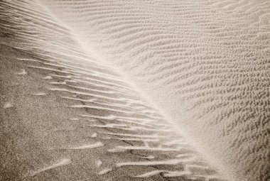 kum ve rüzgar desenleri dune yüzeyi. Desen kum taneleri - karanlık, küçük ve hafif ve daha büyük daha hafif ve ağır olanlar iki tür tarafından oluşturulur. Maspalomas, Gran Canaria, Kanarya Adaları, İspanya