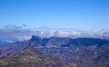 Gran Canaria, Haziran 2018, görüntülemek acrross Caldera de Tejeda, kaya oluşumu Roque Bentayga sol, Altavista dağ convered bulutlar tarafından Teide Tenerife uzak mesafe için