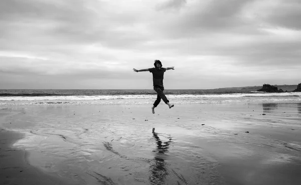 Giovane Una Spiaggia Sabbia Bagnata Facendo Acrobazie Immagine Monocromatica — Foto Stock