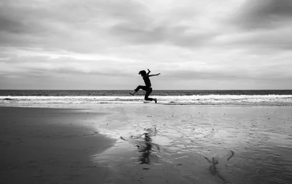 Jovem Uma Praia Areia Molhada Fazendo Acrobacias Imagem Monocromática — Fotografia de Stock