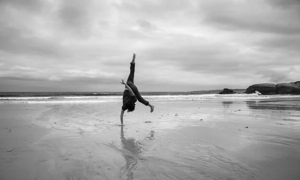 Νεαρός Άνδρας Μια Υγρή Αμμώδη Παραλία Κάνει Ακροβατικά Μονόχρωμη Εικόνα — Φωτογραφία Αρχείου