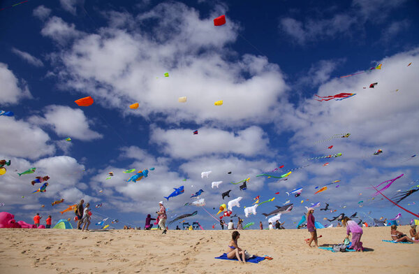 FUERTEVENTURA, SPAIN - NOVEMBER 10: Visitors enjoy beautiful display of flying kites of  at 31th International Kite Festival, November 10, 2018 in Nature park Dunes of Corralejo, Fuerteventura, Spain