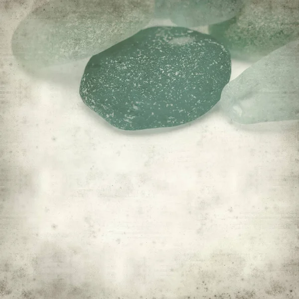textured old paper background with sea glass pieces