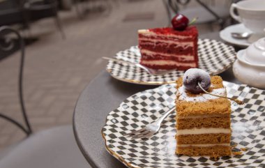 veranda kafede bir masaya ayarlanmış farklı kek iki adet