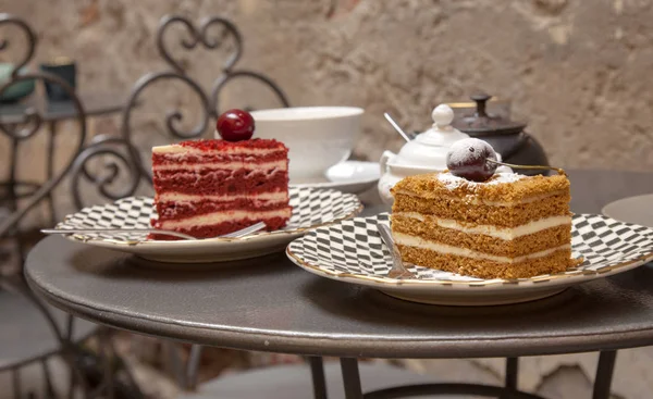 Два куска разных тортов, установленных на столе в патио кафе — стоковое фото