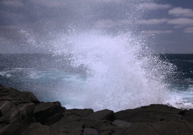 Gran Canaria 'nın kuzey kıyısı, Kanarya Adaları, dalgalar Banaderos bölgesindeki karanlık kayalara çarpıyor.