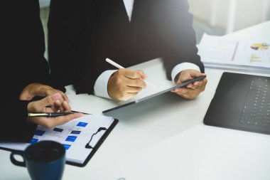 Resmi takım elbiseli iş adamları toplantı sırasında projeyi tartışıyor.