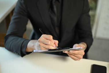 Belgeleri imzalayan ya da not alan işadamlarının ellerini kapatın..