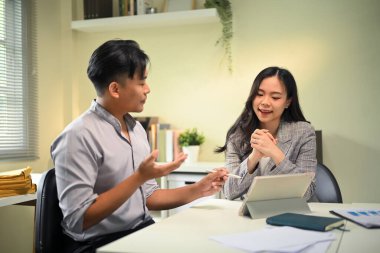 İş arkadaşları modern ofis ortamında iş birliği yapıyor ve fikirleri paylaşıyor.