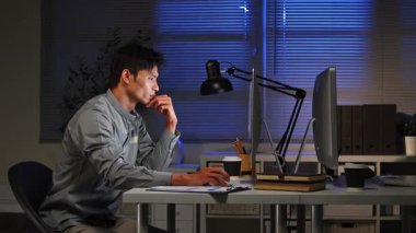 Bilgisayar ekranının önünde uzun saatler geçirdikten sonra vücudu geren yorgun bir ofis çalışanı..