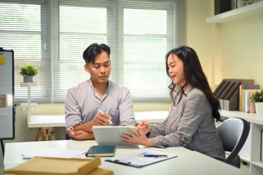 Modern bir ofiste iş birliği, planlama ve proje tartışması yapan iki iş arkadaşı.
