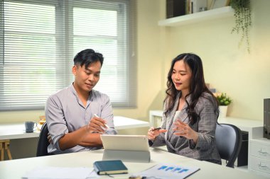 Modern bir ofiste iş birliği, planlama ve proje tartışması yapan iki iş arkadaşı.