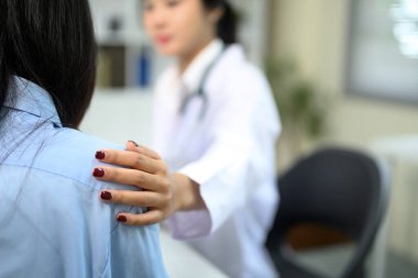 Doktor hasta endişelerini dinlerken empati ve şefkat gösteriyor..