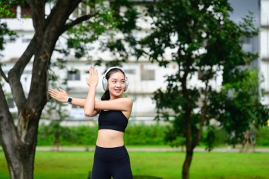 Parktaki antrenmandan önce ısınan bayan sporcu, spor rutinini seviyor..