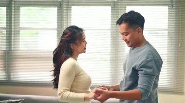 Aşk ve mutluluğu ifade eden romantik çift oturma odasında dans ediyor..