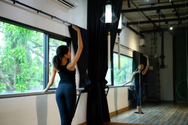 Bale dersinde, barda ayna karşısında pratik yapan zarif genç bir balerin..