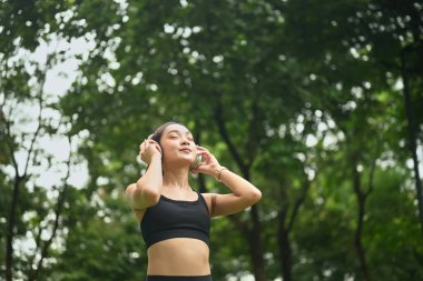Sakin Asyalı koşucu kadın şükranla temiz havanın tadını çıkar..