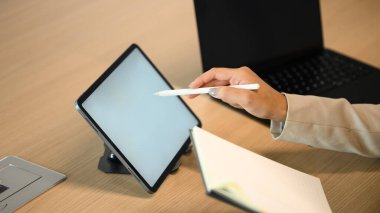 Çalışma masasında tablet kullanan kırpılmış iş kadınları..