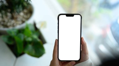 Uygulama modeli veya dijital tasarım sunumu için elinde boş ekranlı akıllı telefon tutan kişi.