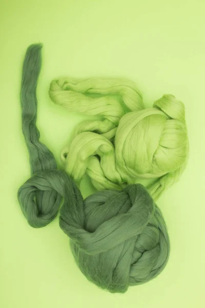 Two Hank merino wool green on a white background