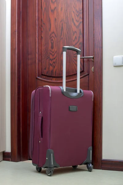 Travel suitcase with pull-out handle at the front door