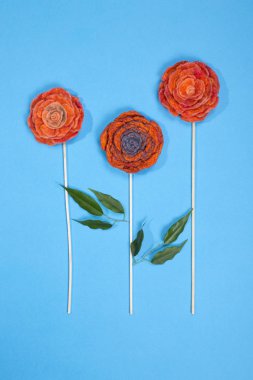 Fulled yün mavi bir arka plan üzerinde bir çiçek şeklinde üç broşlar