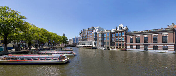 Amsterdam, Netherlands - July 02, 2018: Panorama of the Amstel river embankment in the center of Amsterdam