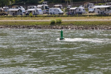 Nehir Ren, Almanya - 07 Temmuz 2018: Nehir şamandıra, Ren Nehri arka planı üzerinde seyir cihazları dinlenme turist kayan bir iz
