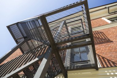 Sabit açık yangın merdiveninde bir binanın duvarına