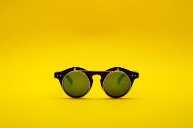 Sarı bir arka plan üzerinde çift camlı güneş gözlükleri