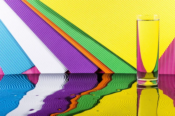 抽象的な色鮮やかな背景に水のガラスと静物画 — ストック写真