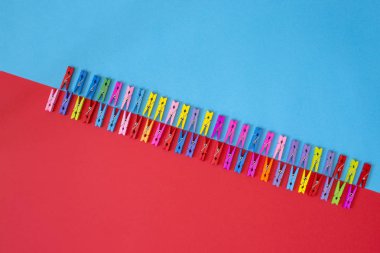 Renkli bir arka plan üzerinde renkli dekoratif clothespins dönüştürün