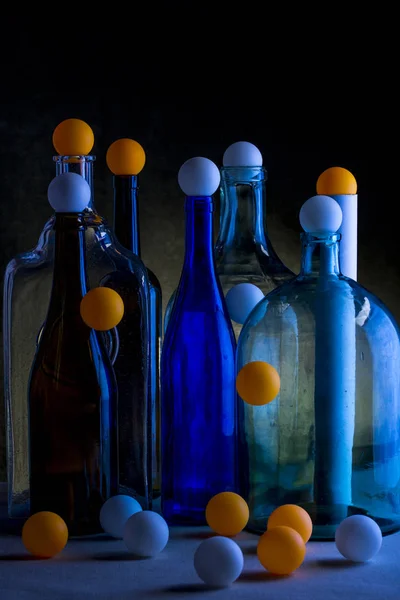 ガラスのボトルや暗い背景に対してボールのある静物 — ストック写真