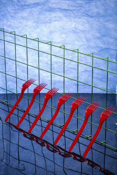 抽象的な静物反射青い背景が付いて赤いフォーク — ストック写真