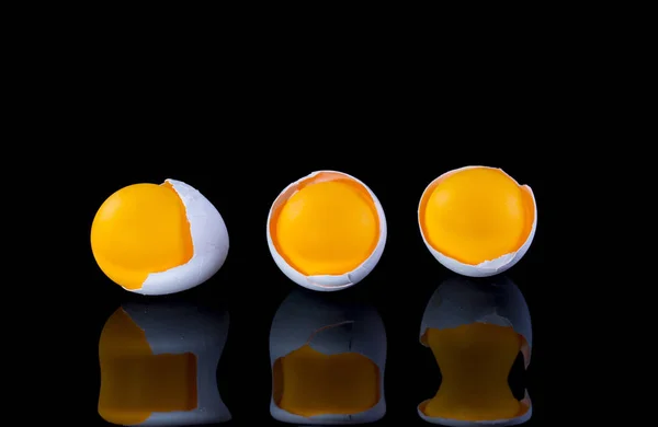 Egg shell with orange ball on a black background