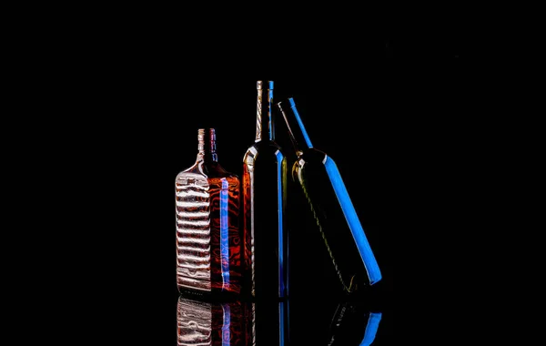Натюрморт со стеклянными бутылками на темном фоне — стоковое фото
