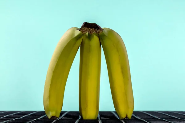Figura Bananas Amarelas Maduras Sobre Fundo Esmeralda — Fotografia de Stock