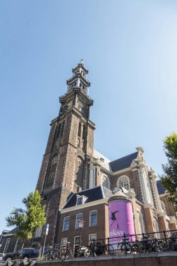 Amsterdam, Hollanda - 02 Temmuz 2018: Protestan Kilisesi Westerkerk Amsterdam'da kanalı'nın kıyısında, kule