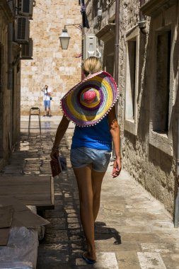 Dubrovnik, Hırvatistan-06 Ağustos 2017: büyük güzel şapkalı bir kız, eski kentin Sokağı boyunca yürüyor.