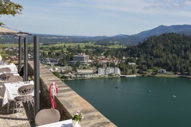 Bled, Slovenya - 15 Ağustos 2019: Slovenya'da bir gölün arka planında Bled Kalesi topraklarında bir kafenin parçası